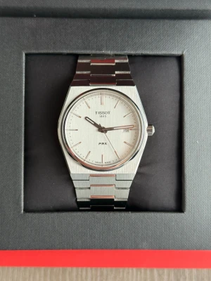 Äkta Tissot PRX 40mm, helt ny, fullset - En helt ny Tissot PRX från 2022 komplett med box, instruktionsbok, taggen och 2 år garantikort (som då har gått ut). Klockan håller tiden perfekt och är helt problemfri, den har stått oanvänd sedan köpet. Det är bara skriva om du önskar fler bilder eller har frågor. Priset är inte spikat i sten OBS byte mot Seiko Presage kan vara aktuellt