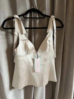 Champagnefärgad satin fest topp - Helt oanvänd silkes topp från Gina tricot 14+ i storlek xs. (Försent att lämna tillbaka) toppen är lite figursydd och i ett tjockt material. Färgen är champagne 💗