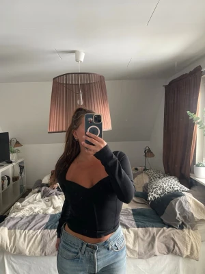 Svart långärmad topp med sweetheart-ringning - Trendig svart långärmad topp med figurnära passform.