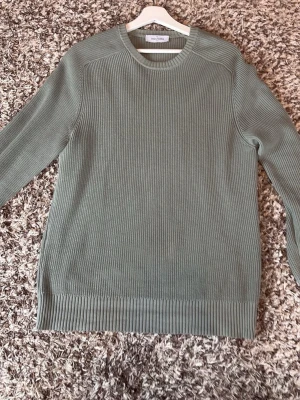 Gran sasso tröja - Snygg grön ribbstickad tröja från gran sasso med rund halsringning och långa ärmar. Tröjan har en stilren och enkel design med breda ribbade muddar vid ärmslut och nederkant. Perfekt för dig som gillar klassisk och clean stil.