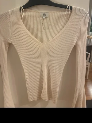 V ringad tight tröja  - Långärmad gräddvit/beige tröja från River Island med superfina utsvänga ärmar. Står att den är strl 4 petite men skulle säga xs. Superfint skick!🥰