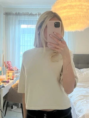 Other stories stickad t shirt - Snygg beige croppad topp med halvärm och rund halsringning. Enkel och stilren design som passar perfekt till jeans eller kjol. Mjuk och bekväm, perfekt för dig som gillar minimalistisk stil.