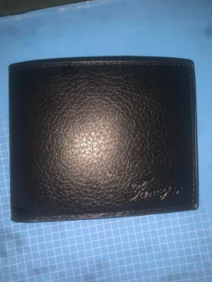 Svart klassisk läderplånbok - Snygg svart plånbok i äkta läder med stilren design. Plånboken har flera kortfack och ett större fack för sedlar. Perfekt för dig som vill ha en enkel och tidlös accessoar i fickan.