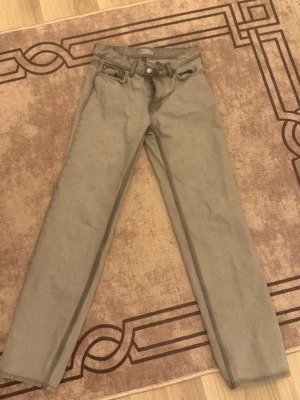 Gråa straight fit jeans från Perfect Jeans - Snygga gråa jeans från Perfect Jeans i rak modell. Klassisk femficksdesign med dragkedja och knapp framtill. Perfekta för en avslappnad och stilren look. Materialet är mjukt och bekvämt, passar till många olika outfits.