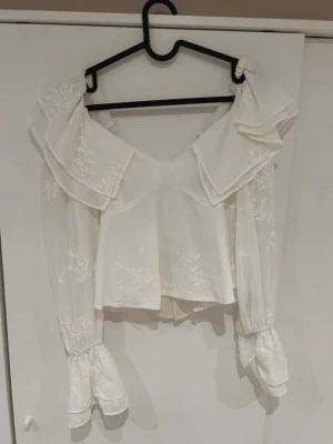 Vit blus  - Vit Volangblus med lite broderi/spets detaljer på 