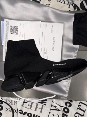 Balenciaga Speed Trainer svarta sneakers - Svarta Balenciaga Speed Trainer sneakers med stickad ovandel och strumpliknande passform. Tjock, futuristisk sula i svart och vit logga på sidan. Minimalistisk design och superbekväma för en modern streetwear-look.