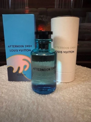 Afternoon Swim parfym Louis Vuitton  - 100 ML Fräsch parfym från Louis Vuitton, Afternoon Swim. Flaskan är blå och genomskinlig med svart lock, och kommer i en stilren vit cylinderförpackning samt en blå kartong med vågmotiv. Perfekt för dig som gillar exklusiva dofter.