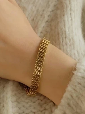 Guldigt kedjearmband - Snyggt armband i guldfärgad metall med platt, bred kedjedesign som ger en modern och stilren look. Perfekt accessoar för att lyfta vilken outfit som helst. Armbandet har en elegant glans och känns både trendigt och tidlöst.