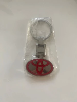 Bil Nyckelringar  -  snygga metallnyckelringar med bilmotiv: en med Toyotas röda logga i oval form och en med Skoda Auto-loggan i grönt och svart. Perfekt accessoar för bilälskare som vill visa sitt favoritmärke på nyckelknippan. 69kr/st , finns fler kvar 
