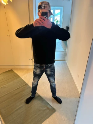 Dsquared2 jeans - Säljer ett par blå jeans med slitningar och hål på båda benen. Jeansen har en smal passform och klassisk femficksdesign. Materialet är denim och de har en modern, streetinspirerad look.