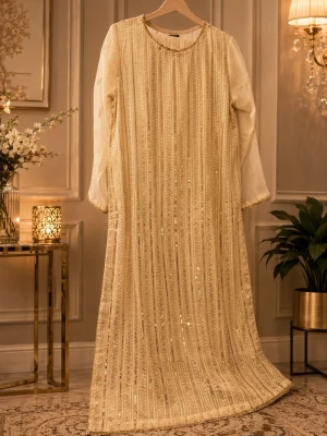 Lång glittrig klänning i champagne comes with trouser and long scarf - Elegant långklänning i champagnefärg med glittriga vertikala ränder. Klänningen har rund halsringning och långa ärmar. Perfekt för speciella tillfällen där du vill glänsa lite extra. Materialet känns lyxigt och skimrande.