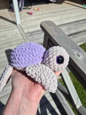 Virkad sköldpadda - Söt virkad sköldpadda med lila skal. Perfekt som dekoration eller gosedjur. Unik och supersöt! Pga säkerhetsögonen bör barn under 3 år inte använda sköldpaddan utan uppsikt. 
