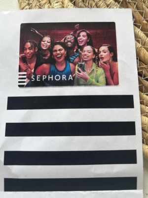 Sephora presentkort - Presentkort från Sephora med färgglad design som visar flera personer med olika sminkstilar. Perfekt för att köpa smink, hudvård eller andra skönhetsprodukter från Sephora. Kortet har en modern och trendig look.
