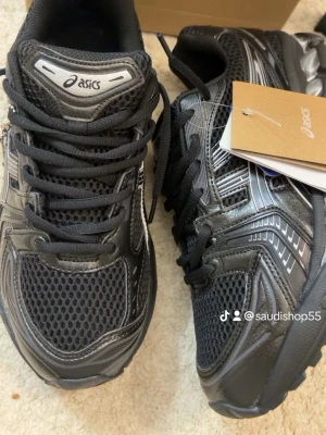 Svarta Asics gel kayano 14 - Snygga svarta sneakers från Asics med silverdetaljer och klassisk logga på sidan. Skorna har meshpaneler för extra ventilation och robust gummisula. Perfekt för dig som gillar sportig stil och komfort. Skorna har snörning och låg profil.