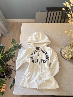 Vit hoodie från Abercrombie & Fitch - Vit hoodie med dragkedja från Abercrombie & Fitch. 