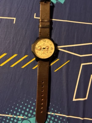 Daniel Klein klocka med brun rem - Stilren klocka från Daniel Klein med rund urtavla i beige och svarta detaljer. Klockan har en brun läderrem och flera små urtavlor för datum och veckodag. Perfekt accessoar för dig som vill ha en klassisk men modern look.