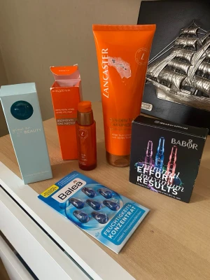 Hudvårdsset med ampuller och after sun - Säljer ett hudvårdsset med produkter från Lancaster, Babor och Balea. Innehåller after sun-lotion, fuktampuller, serum och koncentrat. Färgerna på förpackningarna är orange, blå och svart. Perfekt för dig som vill boosta din hudvårdsrutin med återfuktande och lugnande produkter.