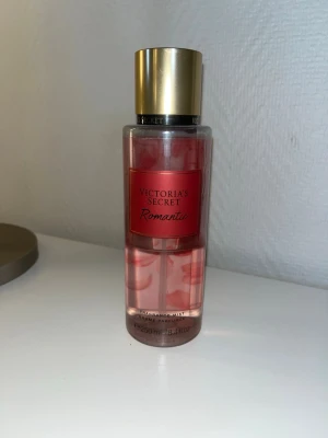 Victoria's Secret Romantic mist - Fräsch body mist från Victoria's Secret i doften Romantic. Flaskan är cylinderformad med guldigt lock och rosa etikett. Innehållet är ljusrosa och flaskan rymmer 250 ml. Perfekt för dig som gillar blommiga och fruktiga dofter. Säljer då den inte används längre💕