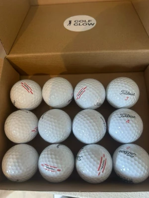 Titleist Truefeel 12-pack - Säljer ett 12-pack vita golfbollar av modellen TruFeel från Titleist. Bollarna har klassisk dimple-yta och märkning i rött och svart. Perfekta för dig som vill ha bra känsla och kontroll på golfbanan. Levereras i en enkel kartong.