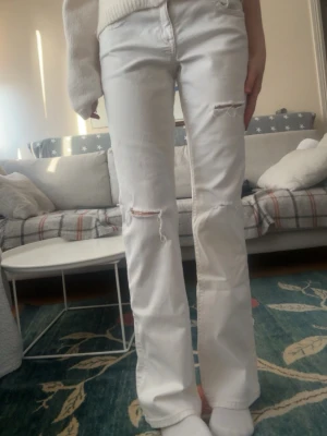Vita Gina bootcut jeans storlek 170 - Säljer dessa vita bootcut  jeans med hål på framsidan, de är från Gina och i jättebra skick. Storlek 170💘😋