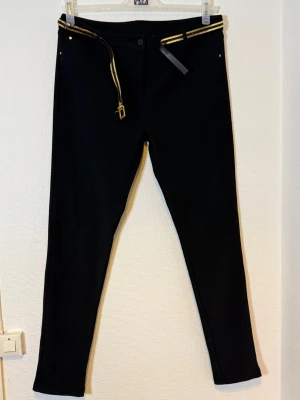 Svarta leggings med gulddetaljer - Midjan 43 cm  Längd 100  cm  Benvidd 26  cm 