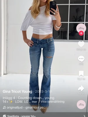 Blå bootcut jeans från Gina Tricot - Säljer ett par blå bootcut jeans från Gina young med låg midja och slitningar. Jeansen har klassisk femficksmodell och är tillverkade i denim med lätt stretch. Perfekta för en trendig och avslappnad look. Sparsamt använda så i väldigt bra skick! 