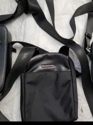 Valentino axelväskor - Oanvända axelväskor från Valentino och guess, justerbar axelrem där loggan är invävd. Väskan har en stilren, värkor är äkta köpt från zalando. Alla 3 väkor för 500kr