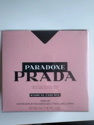 Prada Paradoxe Radical Essence Parfym - Upptäck Prada Paradoxe Radical Essence, en exklusiv parfym i elegant rosa förpackning med svart och silverdetaljer. Flaskan rymmer 50 ml och är en påfyllningsbar spray. Doften är modern och lyxig, perfekt för dig som vill sticka ut.