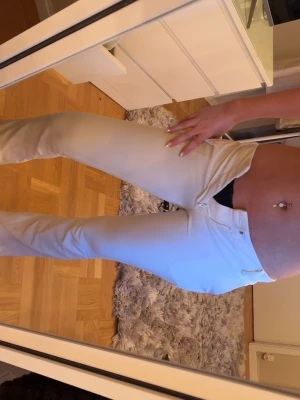 Vita kostymbyxor med låg midja och slits - Snygga kostymbyxor med slim fit och låg midja. Slits på yttre byxbenen. Säljer få försmå. 