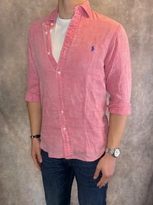 Rosa Ralph Lauren Linneskjorta - Stl S, Slim fit - RIKTIGT FET LINNESKJORTA FRÅN RALPH LAUREN I FÄRGEN Rosa med blå pony, perfekt till sommaren som närmar sig! 🏖️🌊 | Mycket bra skick: 9,5/10, utan defekter! | Stl: M |  Modellen är 176cm och väger 75kg,  | Hör av dig vid frågor // Galgen 🫡