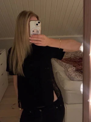 Svart t-shirt - Säljer en snygg svart t-shirt med spets i ryggen och slits på sidorna! Bara använt den två gånger. 