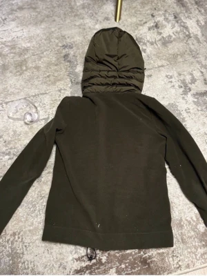 Mörkgrön Moncler cardigan  - Vi säljer en mörkgrön moncler cardigan i väldigt bra skick, det vita smutset på första bilden är inget som kommer med när den skickas(ingen fläck) finns äkthets bevis från vesitaire collective. Vid fler frågor är det bara att höra av sig! 