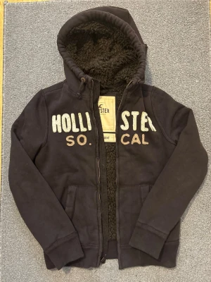 Pälsfodrad Hollister Kofta - Säljer denna snygga Hollister koftan som även är pälsfodrad, varm & skön till kalla dagar | Mycket bra skick | Storlek S | Längd ≈ 68cm, Bredd armhåla-armhåla ≈ 57cm | Modell 175, 68kg