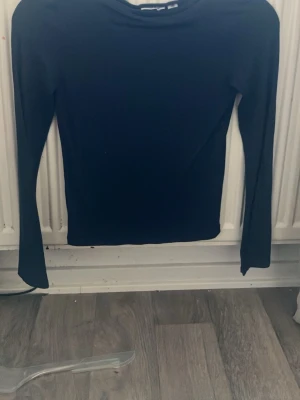 Mörkblå långärmad topp - En enkel och stilren mörkblå långärmad topp med rund hals. Perfekt att matcha med jeans eller kjol för en clean look. Tillverkad i mjukt material som känns skönt mot huden.