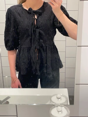 Svart mönstrad knytblus med puffärm - Inga defekter, aldrig använd och är som nytt skick!