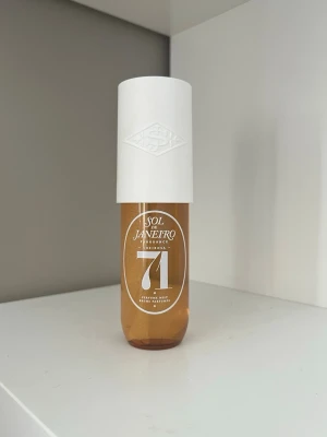 Sol de Janeiro Cheirosa 71 Parfymmist - Sol de Janeiro Cheirosa 71 är en parfymmist i en genomskinlig brun plastflaska med vit spraykork och lock. Flaskan har en modern, stilren design med tydlig logga och siffran 71 på framsidan. Perfekt för dig som gillar söta och varma dofter.