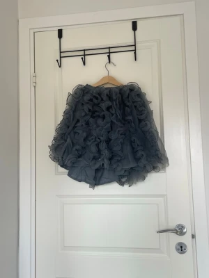 volangkjol - Säljer denna volangkjolen i färgen blå-grå. Kanske använt några gånger för några år sedan, men inget tror ej det eftersom att prislappen är kvar.