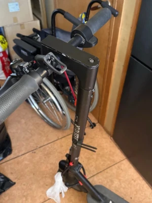 Svart elsparkcykel med grå detaljer - Säljer en svart elsparkcykel med grå handtag och röda detaljer vid bromskabeln. Modellen har en robust ram och bred fotplatta med ett E-märke. Perfekt för att ta sig fram snabbt i stan. Laddningsuttag och stöd finns på sidan. 20 km i timmen