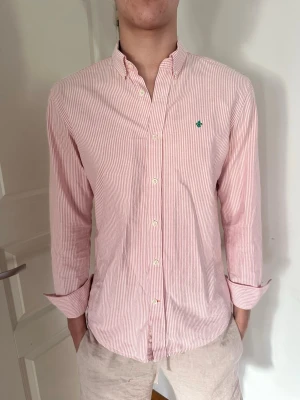 Rosarandig Morris Skjorta - Säljer denna feta Morris skjortan, rosarandig och passar perfekt till det varmare vädret som är på ingång. Storlek M, modellen är 187, 75kg.