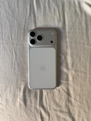Apple iPhone 17 Pro Max 256gb - Säljer en Apple iPhone 17 PRO Max i snygg silverfärg med stilren design och glasbaksida. Telefonen har tre stora kameralinser på baksidan och en modern skärm med tunna kanter och Dynamic Island. Perfekt för dig som vill ha en kraftfull och elegant smartphone.