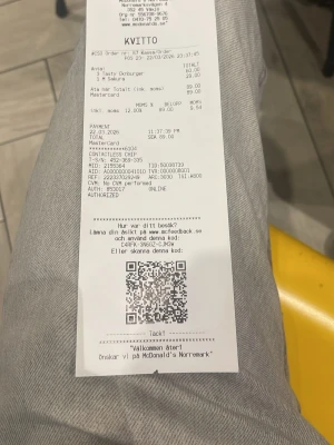 67 McDonald's kvitto med QR-kod - Kvitto från McDonald's Norrtull med detaljer om beställning, betalning och en QR-kod för feedback. Kvitto är tryckt på vitt papper och innehåller information om köpta produkter och betalningsmetod.