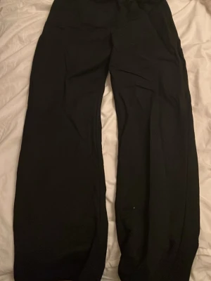 Svarta linnebyxor - Säljer ett par svarta linnebyxor med breda ben och hög midja. De har en enkel och stilren design utan synliga detaljer eller mönster. Perfekta för dig som gillar en avslappnad och trendig look.