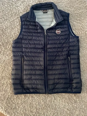 Mörkblå dunväst från Colmar - Snygg mörkblå dunväst från Colmar. Inga synliga defekter. Storlek 16 Y men passar som S.