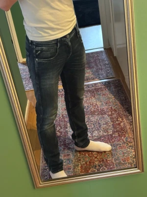 Mörkblå slim fit jeans från Replay - Snygga blå slim fit jeans från Replay med slitna detaljer och ljusa tvättade partier på låren och knäna. Klassisk femficksmodell med Replay-lapp bak i midjan. Perfekta för dig som gillar en modern och avslappnad stil.