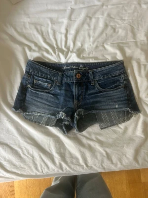 Blå jeansshorts American Eagle - Jättesnygga blå jeansshorts från American Eagle. Shortsen har låg midja och slitna detaljer, perfekta till sommaren!💗 pris kan diskuteras! Hittar ingen lapp med storleken men skulle säga S då dem är för små för mig som vanligtsvis har M💗