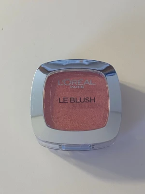 L'Oréal Paris Le Blush rosa puderrouge - Säljer ett L'Oréal Paris Le Blush i en snygg rosa nyans. Rouget kommer i en kompakt fyrkantig dosa med genomskinligt lock och silvrig ram. Pudret har en lätt skimrig finish som ger kinderna en fräsch glow. Har ej använts så mycket utan mest swatchats och innehåller fortfarande ganska mycket produkt!  