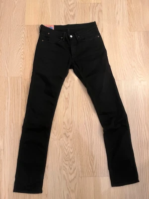  Acne Studios Svarta jeans Max  - Säljer ett par svarta jeans från Acne Studios Blå Konst. Klassisk femficksmodell med raka ben och nitar. Jeansen är  en smal modell stilren look är tillverkade i bomull.