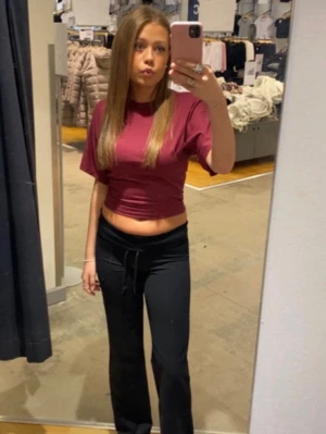 Vinröd croppad t-shirt - Säljer en vinröd croppad t-shirt med korta ärmar och rund hals. Perfekt för dig som gillar en enkel och stilren look. Materialet är mjukt och känns som bomull, vilket gör den bekväm att bära. Passformen är normal och toppen är enkel att matcha med jeans eller kostymbyxor.