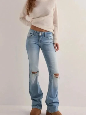 Lågmidjade Nelly jeans med hål  - Har fickor med knappar där bak. Sydda lite mer lowaist! 