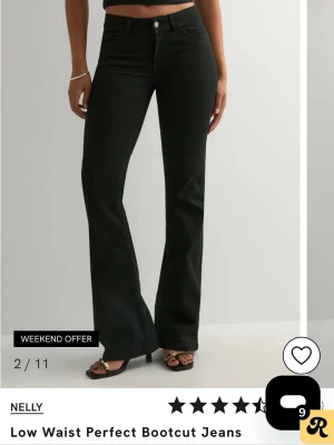 Svarta bootcut jeans från Nelly - Snygga svarta bootcut jeans från Nelly med låg midja och klassisk femficksdesign. Jeansen har utsvängda ben och stängs med knapp och dragkedja. Perfekta för dig som gillar en trendig och avslappnad look.